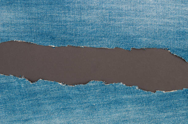 istock Torn edge grunge denim material   on a black  background 1444971410