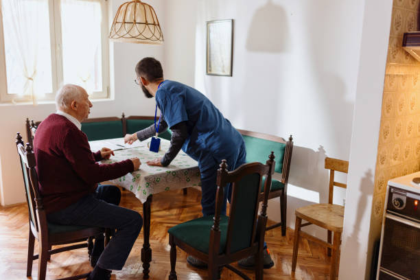 istock Care worker giving an old man lunch in his home. 1444971457