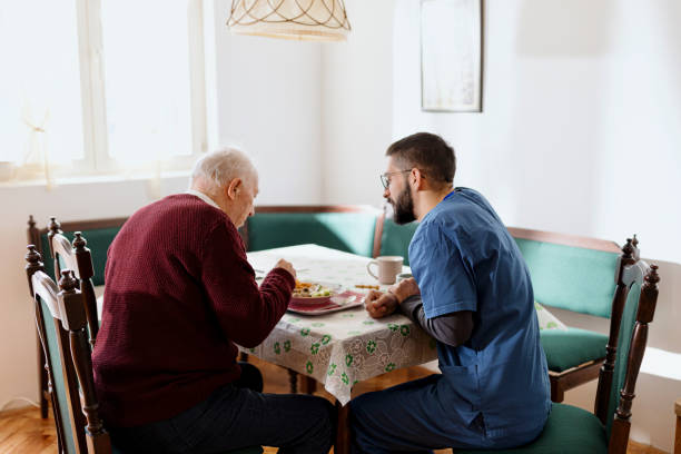 istock Caretaker helping man eat during lunch time 1444971708