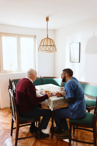 istock Caretaker helping man eat during lunch time 1444971745