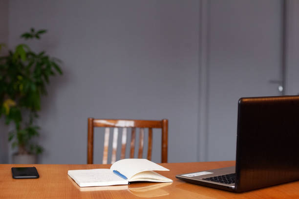 istock Empty office workplace with laptop, notebook and smartphone on wooden table 1444971756