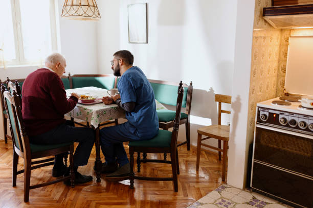 Caretaker helping man eat during lunch time