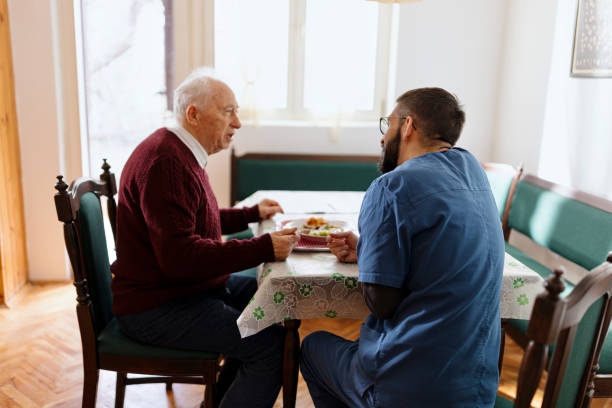 istock Caretaker helping man eat during lunch time 1444971767