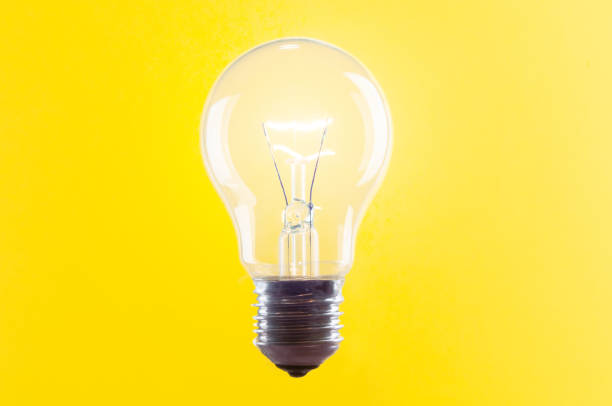 istock Vintage glowing  light bulb close up on yellow background 1444971874
