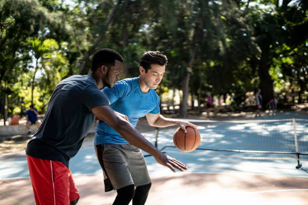 Young friends having a basketball match at a sports court