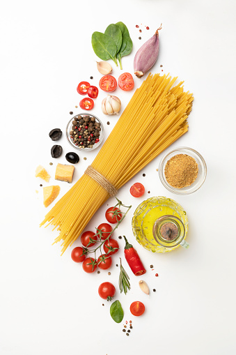 Set of healthy food ingredients isolated on white background, raw fettuccine pasta, cherry tomatoes, parmesan