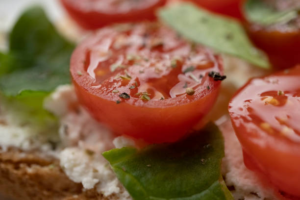 toasts with feta cheese and cherry tomatoes on a white dish, macro shot, healthy snack