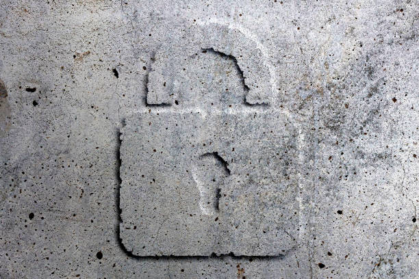 istock Security protection padlock symbol carved in concrete bunker wall 1444980341
