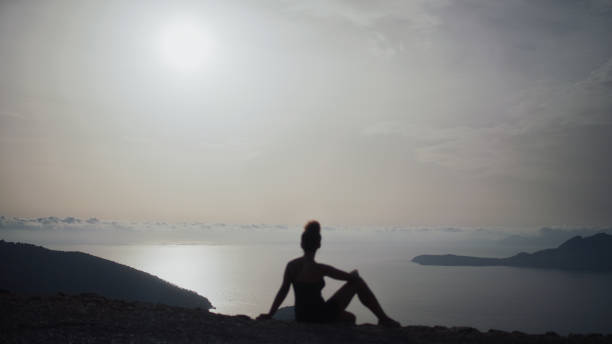 istock African ethnicity woman relaxing on a cliff and watching a sunset 1444981213