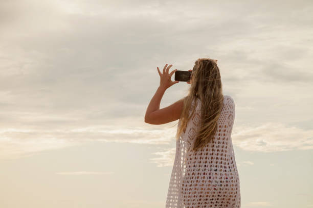 istock Woman with her back on dune at sunset. 1444985498