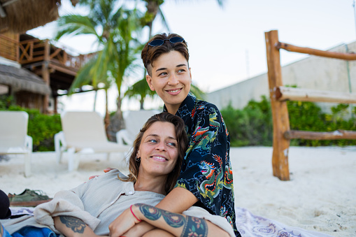 Portrait of lesbian couple sitting on the beach