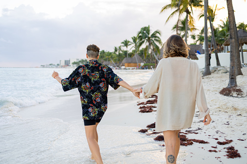 Same-sex couple walking on the beach and they are enjoying