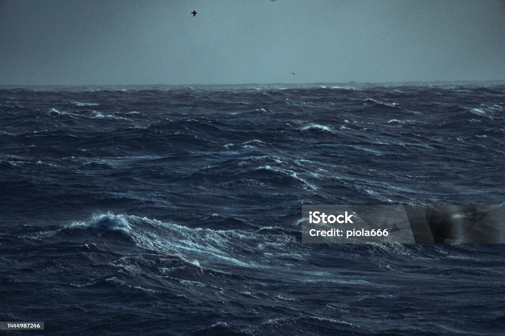 Rough sea and waves of the ocean from a boat View on a rough sea, with waves of the open ocean from a boat. Dramatic landscapes of the Atlantic Ocean. Adventure Stock Photo