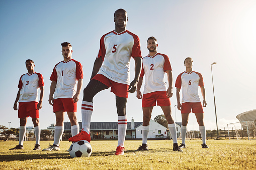 Men, soccer and team for game on sports field in fitness, exercise and training in the outdoors. Group of confident professional football players standing together ready for a match on a sunny day