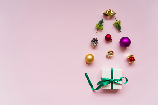 Christmas tree of Christmas Ornaments on pink colored background.