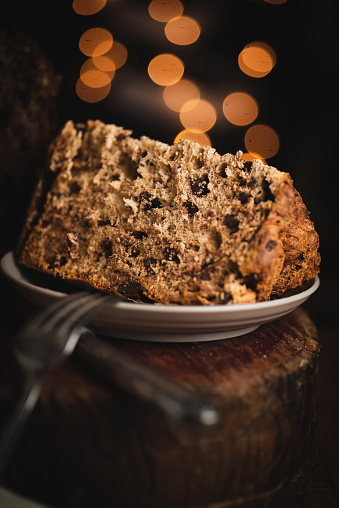christmas panettone, on wood, with out-of-focus background lights, copy space