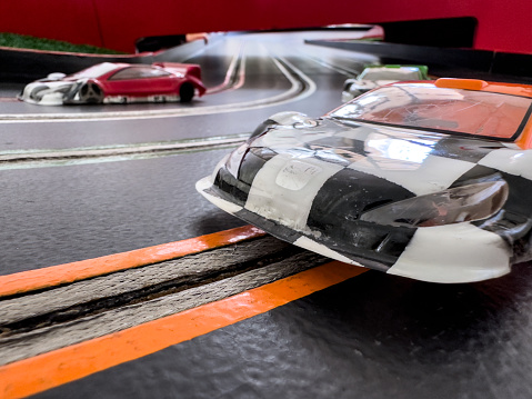 Close front view of a red race car on a track. High resolution 3D render.