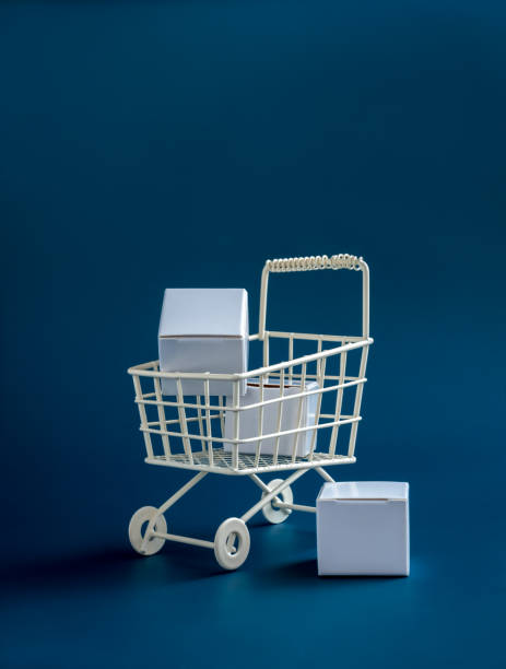istock Shopping online business, e-commerce, delivery, purchasing power concepts. White parcel boxes in shopping trolley cart supermarket isolated on blue background, vertical, minimal style. 1444996936