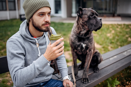 Man and a dog are sitting on a bench