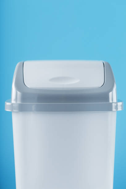 istock White trash can on a light blue background with free space. 1444998340
