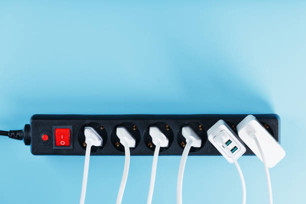 istock Electric mains filter with inserted white plugs of electrical appliances on a blue background. 1444998434