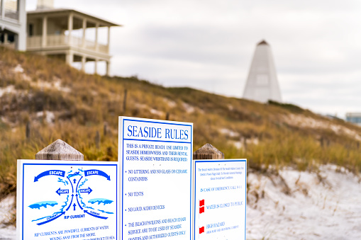 Seaside, Florida panhandle with beach rules sign poster for danger rip currents, no trash and littering in new urbanism small town city