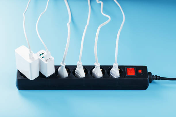 istock Electric mains filter with inserted white plugs of electrical appliances on a blue background. 1444998591