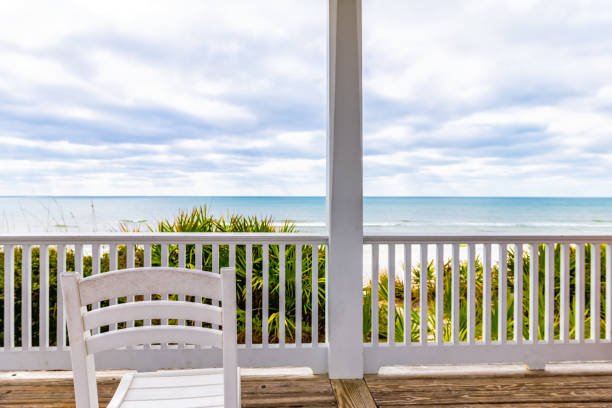 seaside, florida weißer hölzerner pavillon architektur mit blick auf den golf von mexiko ozean am wasser, stuhl am geländer - beach house stock-fotos und bilder