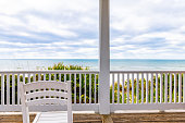 Seaside, Florida white wooden gazebo pavilion architecture with Gulf of Mexico ocean waterfront beach view, chair by railing