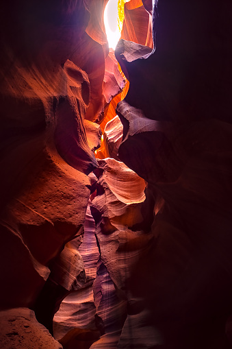 Wide angle vertical view of shadows light at upper Arizona Antelope slot canyon, wave shape abstract sandstone rock formations of red orange layers