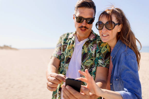 istock Mature couple looking at phone on the beach 1444999990