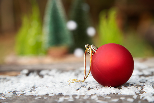 Christmas snow covered tree and red ball, close up. Winter season, cold and snow falling. Holiday greeting card. 3d render