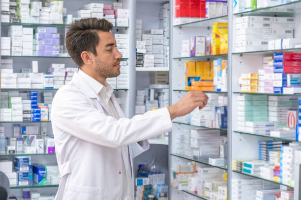 istock young pharmacist holding medicine looking at camera 1445000901