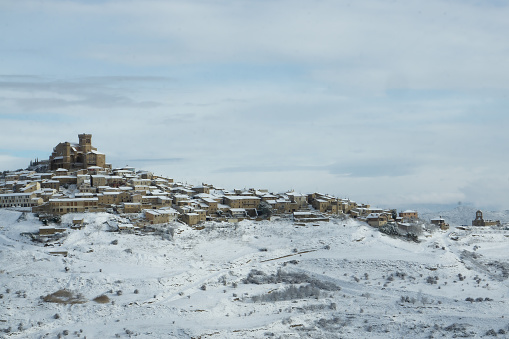 Perspective of a medieval village, on a hill, covered with snow