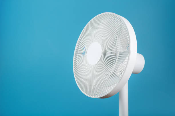 istock Electric fan in white with a modern design for cooling the room on a blue background 1445005268