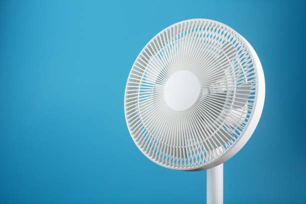 istock White modern electric fan for cooling the room on a blue background. 1445006016