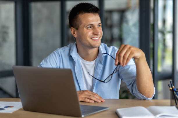istock Successful happy man, office worker or entrepreneur, working in modern office, looks away and thinks about something and smiles friendly 1445006755