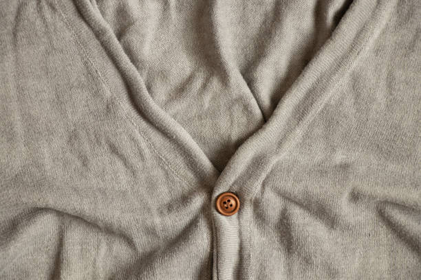 Two small buttons sewn on pink knit wool fabric closeup