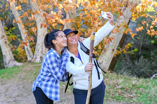 Mother and daughter taking selfies while hiking