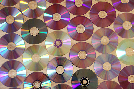 CDs pattern. Attributes of the 1990s. Memory entries. Video memory recording. Hobby of the 90s. Passion for music in the 1990s. Compact disks. Texture from CD