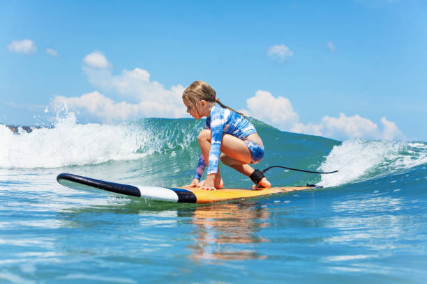 młody surfer jeździ na desce surfingowej z zabawą na falach morskich - co surfing zdjęcia i obrazy z banku zdjęć