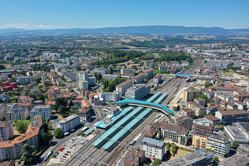 Renens is a municipality in the canton of Vaud and a suburb of the city of Lausanne. The image shows several new buildings next to the railway tracks, captured during summer season.