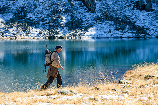 Fisherman hiking at a lake in the mountains