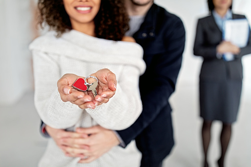 Happy couple holding key for a new apartment /close up/