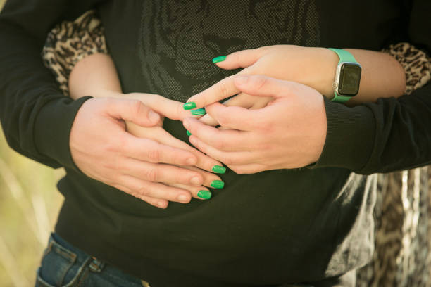 istock Lovers in the park tenderly hold hands together, blurred background. 1445016397