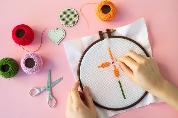 istock Floral pattern in hands on canvas. Cross stitch technique. Hobby, handmade home decor concept. DIY. 1445016698