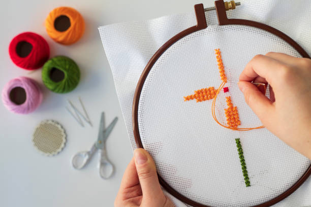 istock Floral pattern in hands on canvas. Cross stitch technique. Hobby, handmade home decor concept. DIY. 1445016732