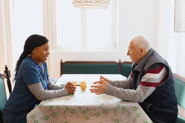 istock Friendly nurse talking to senior male patient 1445018138