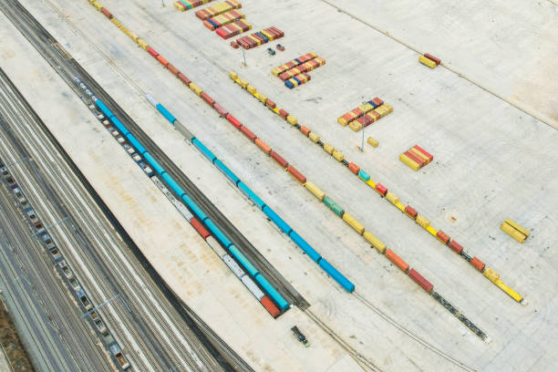 istock Shipping containers in logistics center and train tracks on its side, drone view 1445019057