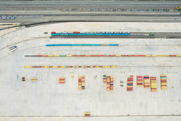 istock Shipping containers in logistics center and train tracks on its side, drone view 1445019061